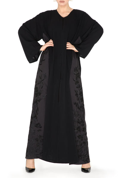 Black chiffon abaya featuring a flowy silhouette adorned with contrast  embellishment.